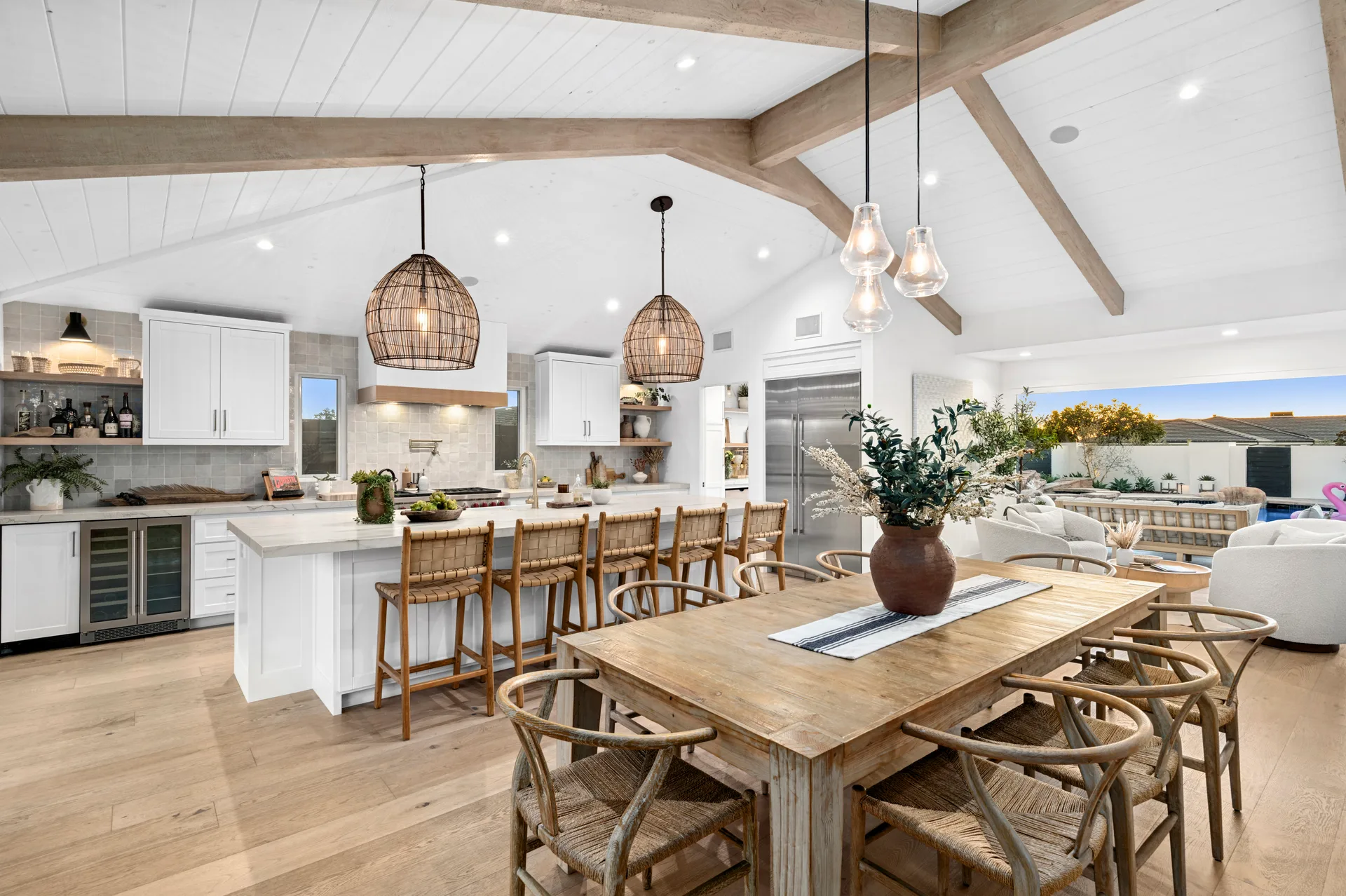 Open kitchen and dining under exposed beams in a Corona del Mar remodel by Drake Construction