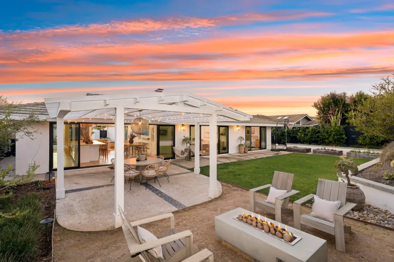 Pergola and lit interiors at dusk — 1214 Outrigger Dr, Corona del Mar